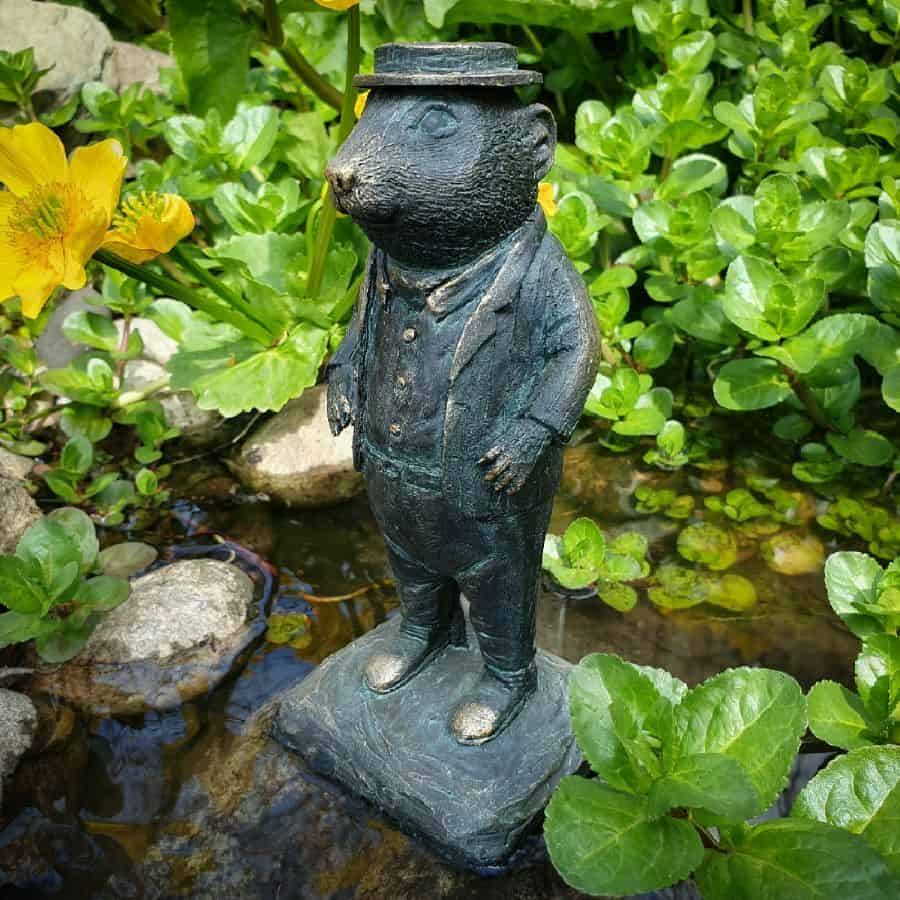 Ratty from Wind in the Willows featuring bowler hat and waiste-jacket. Situated in the pond of a British garden