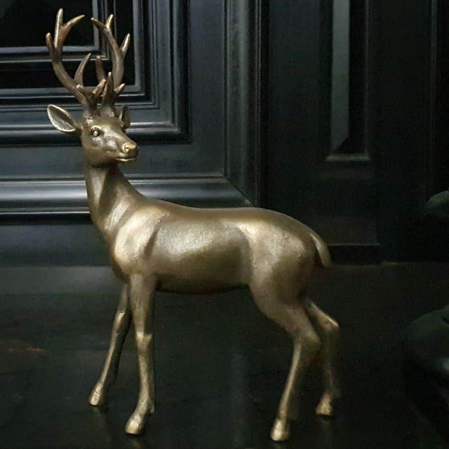 A reindeer/stag looking curiously over their shoulder as if to bolt with impressive antlers.