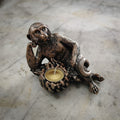 A monkey laying side on with a tealight made of bananas.