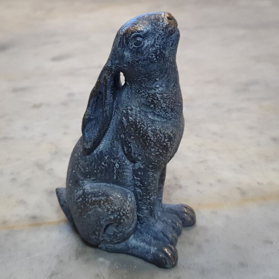 A hare sitting upright with ears folded back, gazing as if at the moon. Situated on the marble table of a British home