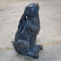 A hare sitting upright with ears folded back, gazing as if at the moon. Situated on the marble table of a British home