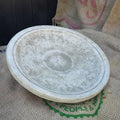 The top half of a birdbath feeder of grey stone. Situated on the hessian sack of a photography studio