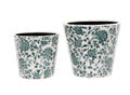 Two ceramic planters of medium and large size featuring intricate floral design of green. Situated on a white studio background