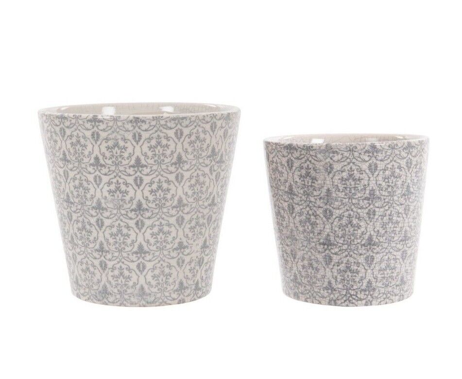 Two ceramic pots of large and medium size featuring floral design. Situated on the white background of a photography studio