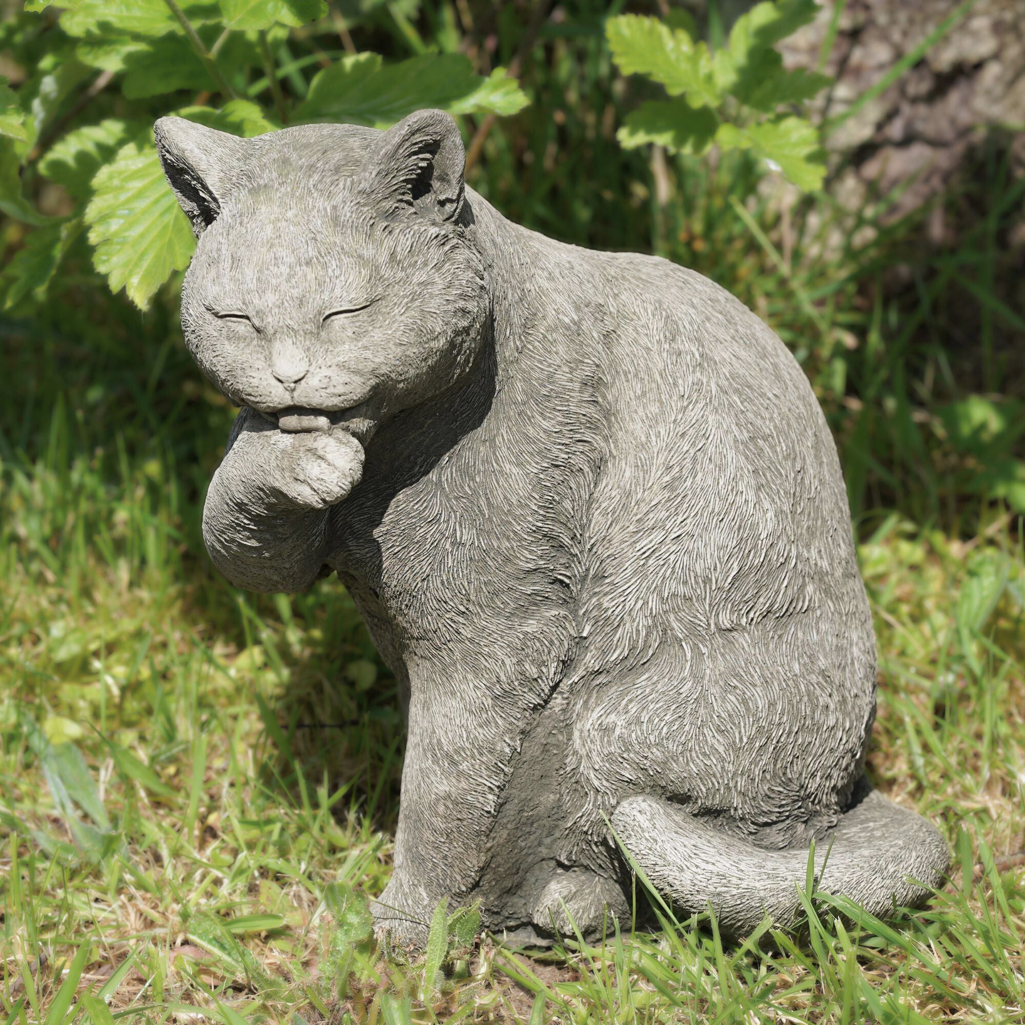 a stone statue of a cat for use as a garden ornament.