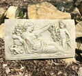 A laying roman lady featured on a rectangular hanging plaque. Situated on the ground of a british garden