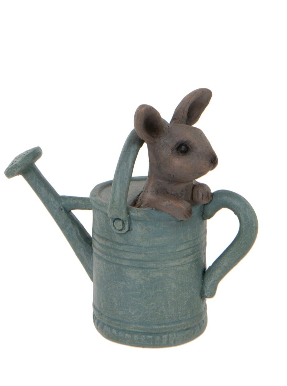 A little rabbit with a curious look sitting in a blue watering can