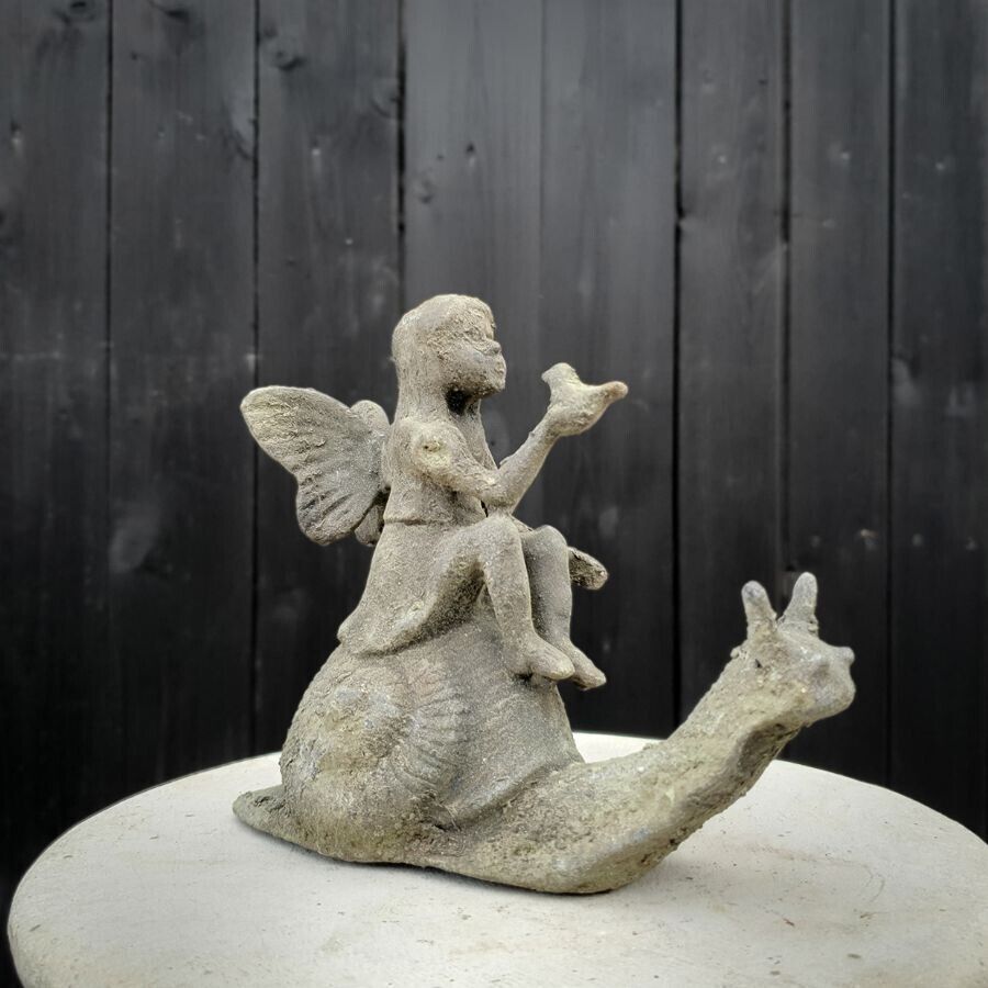 A fairy singing to a bird in her hands whilst traveling on a snail. situated in front of a British garden fence