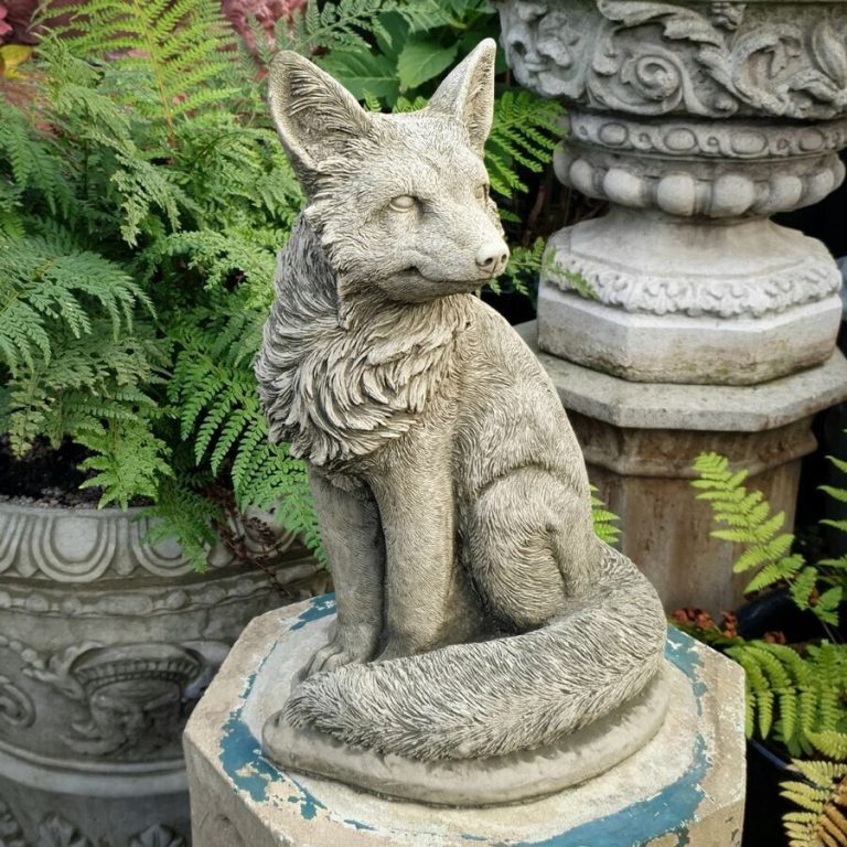 A fluffy tailed fox sitting with flowing main and happy face. Situated amongst the flower pots of a British garden